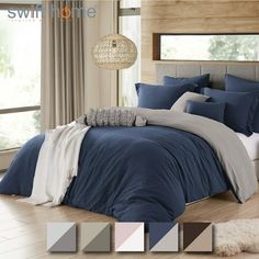 a bed with blue and grey comforters in a bedroom