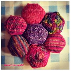 several knitted balls are arranged in a circle on a checkered tablecloth with the words, week 7 love puns