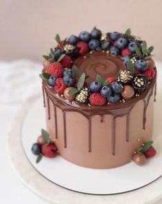 a chocolate cake with berries, raspberries and chocolate drizzle on top