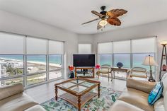 a living room filled with furniture and large windows