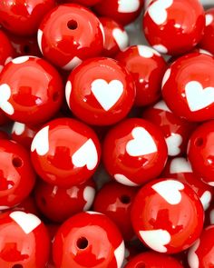 red beads with white hearts on them are shown in close up view, as if they were made out of plastic