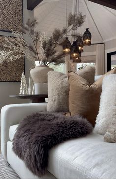 a living room filled with lots of furniture and pillows on top of a white couch