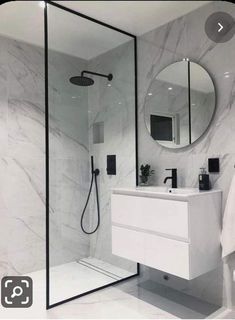 a bathroom with marble walls and flooring, including a walk - in shower next to a sink