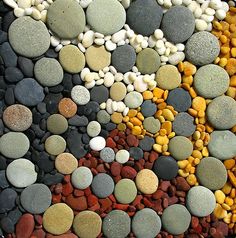 a bunch of rocks that are laying on the ground with different colors and shapes in them