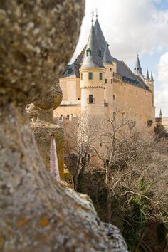 an old castle is seen through the rocks