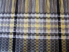 a close up view of a plaid fabric with yellow and black stripes on it's edges