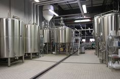 several stainless steel tanks in a large room