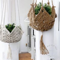 two hanging planters with plants in them on the side of a wall next to a door