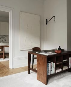 a room with a table, chair and bookshelf