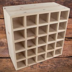 a wooden shelf with many cubbys in it on a wood floor next to a wall