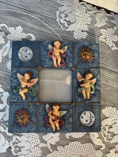 an altered photo frame with angels and sunflowers in it on a lace doily