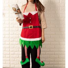 a woman in an elf costume is reading a book while standing against a brick wall