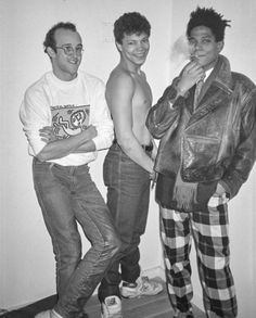 three young men standing next to each other in front of a white wall and wearing plaid pants