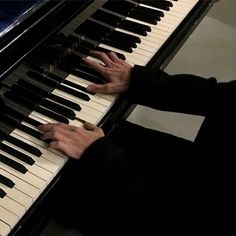 a man is playing the piano with his hands and fingers on it's keys