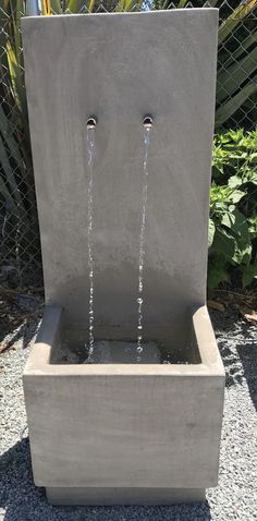 an outdoor fountain with water running from it's faucet to the ground