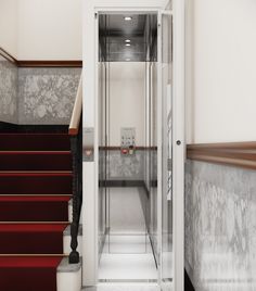 an empty hallway with red stairs and white walls