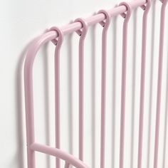 a close up of a pink metal bed frame with four bars on the top and bottom