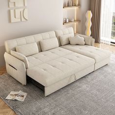 a white couch sitting on top of a rug in a living room next to a window