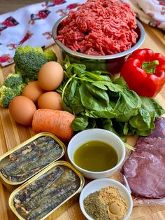 an assortment of meats and vegetables on a cutting board