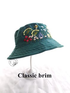 a green hat with flowers on it and the words classic brim above it in white