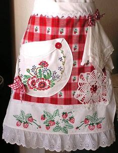 a red and white checkered apron with lace on the bottom, an appliqued strawberry patchwork