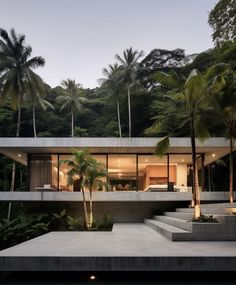 the house is surrounded by palm trees and has stairs leading up to it's upper level