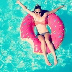 a woman floating on an inflatable ring in the water with her arms outstretched