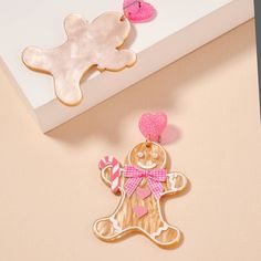 a cookie shaped like a ginger with a pink bow on it's head next to a box