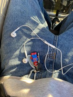 a pair of headphones attached to the back of someone's jeans on a car seat