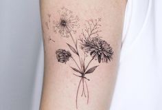 a black and white photo of flowers on the right arm, with dandelions in the background