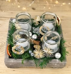 a tray filled with candles and ornaments on top of a wooden table