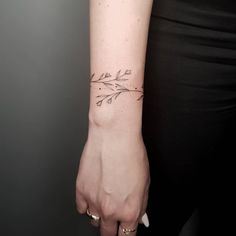 a woman's arm with an arrow tattoo on the left side of her wrist