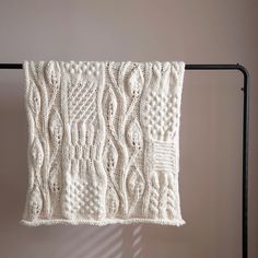 a white knitted dishcloth hanging on a rack