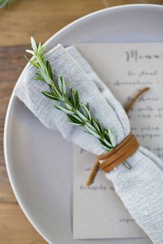 a place setting with napkins and rosemary sprigs