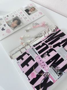 a pink and black binder with some pictures on the wall next to each other