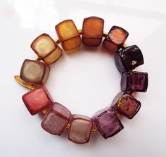 Introducing my Earth Tones Geometric Cubes Statement Bracelet, a unique and eye-catching accessory that will elevate your style to a new level! This stunning bracelet features a modern and geometric design. The color palette is inspired by nature's earth tones, with warm and rich hues such as deep browns, rustic oranges, and soft grays, adding a touch of warmth and natural elegance to your ensemble. This bracelet is not only a fashion statement but also a piece of wearable art that celebrates yo Lampwork Glass Jewelry, Jewelry Website Design, Lampwork Bracelets, Funky Necklace, Geometric Bracelet, Designer Bracelet, Glass Cube, Glass Beads Jewelry, Light Amethyst