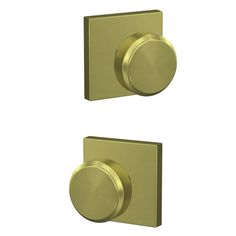 two brass - plated door knobs on white background