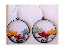 the earrings are made out of metal and have colorful flowers on them, as well as words