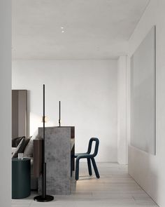 a room with white walls and flooring, two blue chairs in the foreground