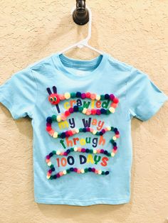 a t - shirt that says i painted my way through 100 days hanging on a wall