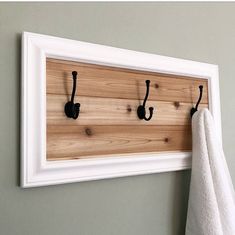 a towel rack with three hooks on it and a white towel hanging from the wall