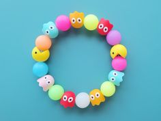 a bracelet made out of plastic beads with different colored fish faces on each bead