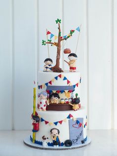 a three tiered cake decorated with figurines and flags on it's sides