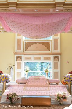 the bed is covered with pink sheets and flowers