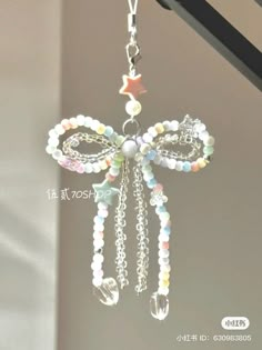 a close up of a key chain attached to a window sill with beads and charms hanging from it