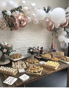 a table topped with lots of food and balloons