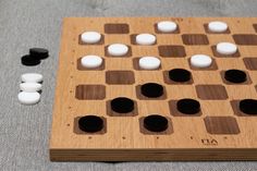 a wooden board game with white and black pieces