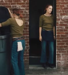 two women standing in front of a brick building with their backs turned to the camera