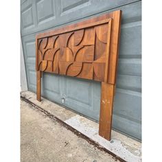 a wooden headboard sitting on the side of a building next to a garage door