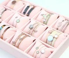 a pink jewelry box filled with lots of bracelets and rings